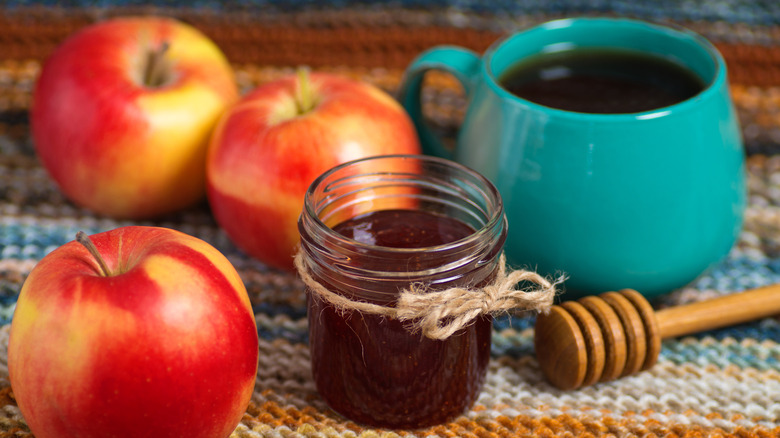 honey jar beside apples