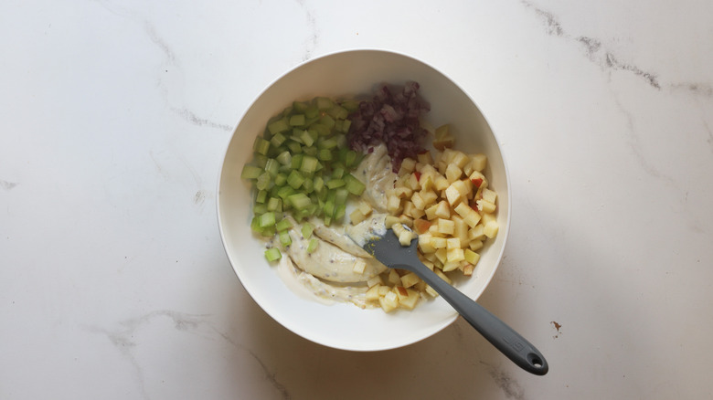 Marinated apples added to bowl