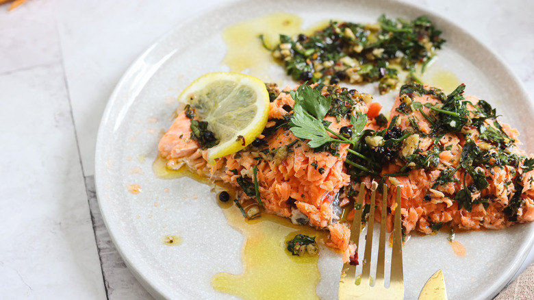 Flaking salmon in plate with fork