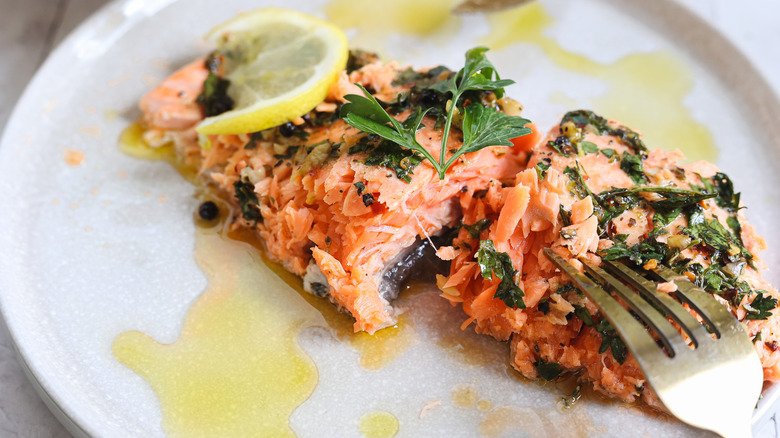 Flaking salmon in plate with fork