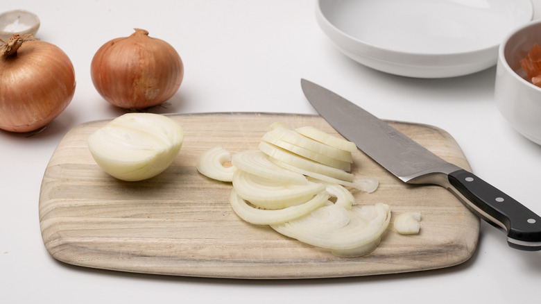 slicing onions on chopping board