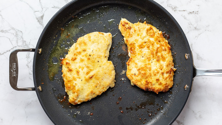 chicken breast frying in pan