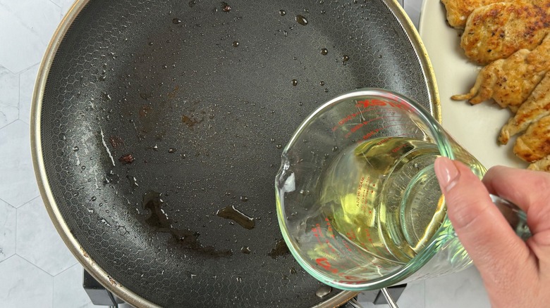 pouring white wine into skillet