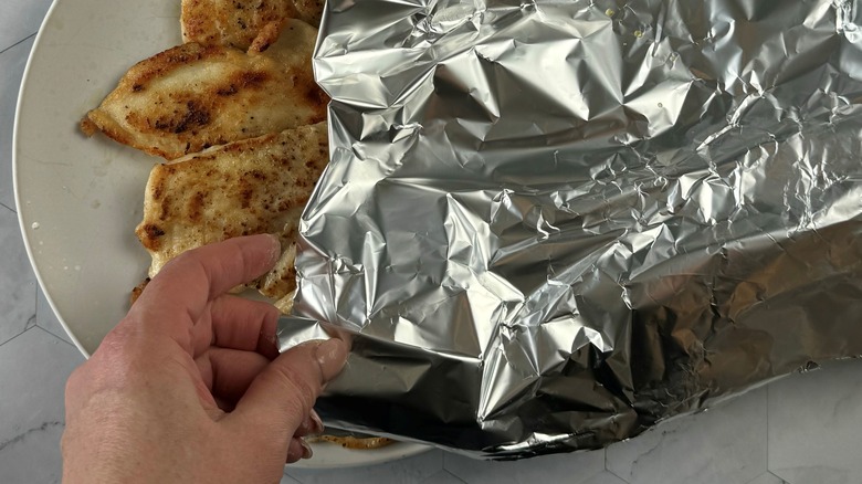 chicken on plate covered with foil