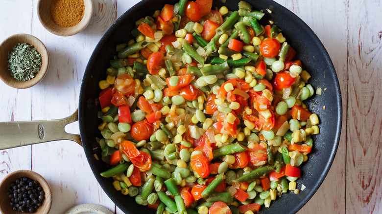 Pan of succotash with herbs around