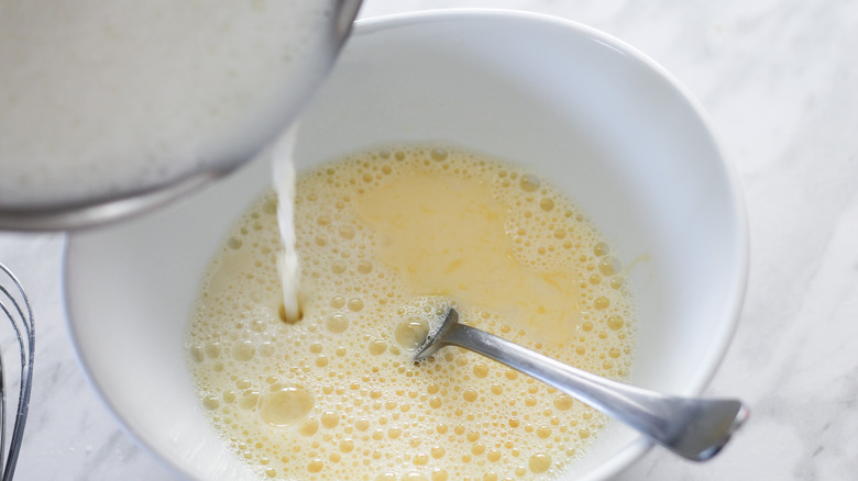 pouring milk into yolk mixture