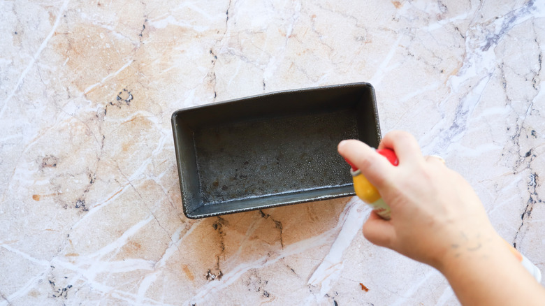 Hand greasing loaf pan