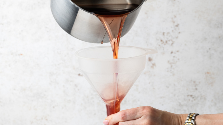 pouring grenadine into bottle 