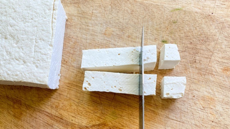 tofu being cut into cubes