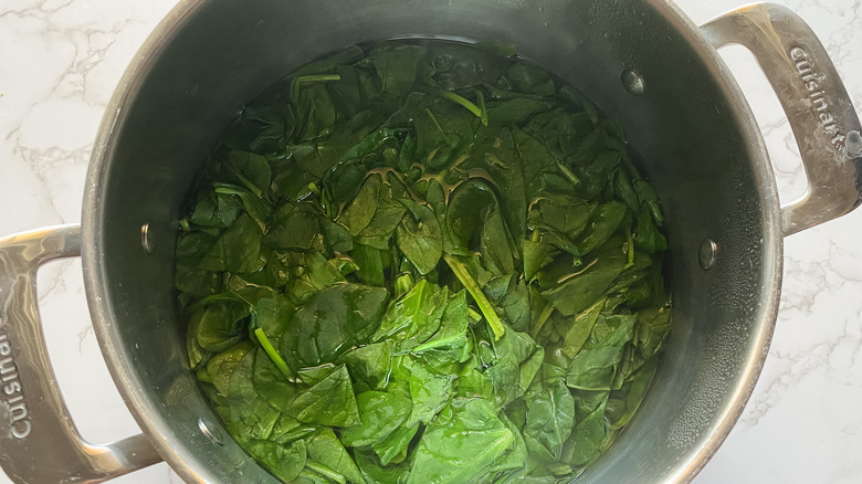 spinach cooking in a pot of water