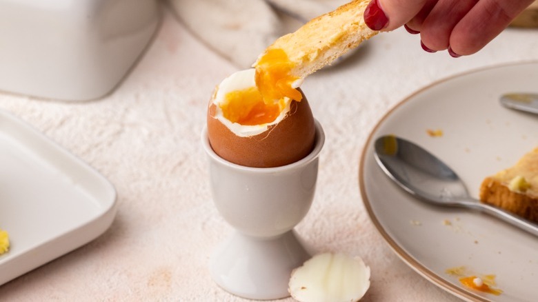 dipping bread into soft-boiled egg