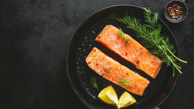 Salmon fillets skin-side down cast iron pan 