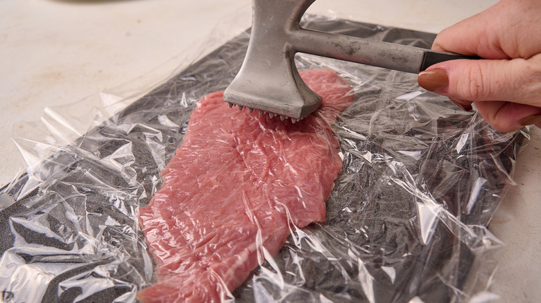 tenderizing veal with meat mallet