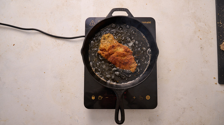 frying breaded cutlet in a skillet