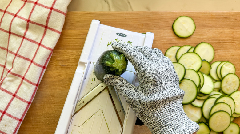 hand slicing zucchini on mandoline