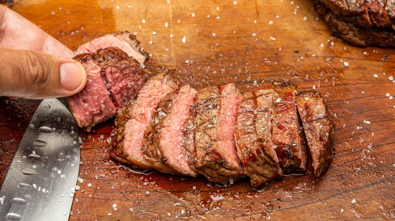 hand touching tri-tip steak