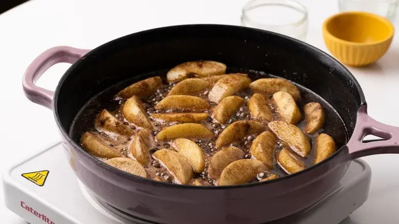 apples slices frying in a cast iron skillet