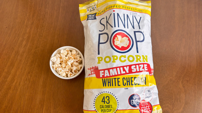 Bag of Skinny Pop popcorn next to small bowl of popcorn