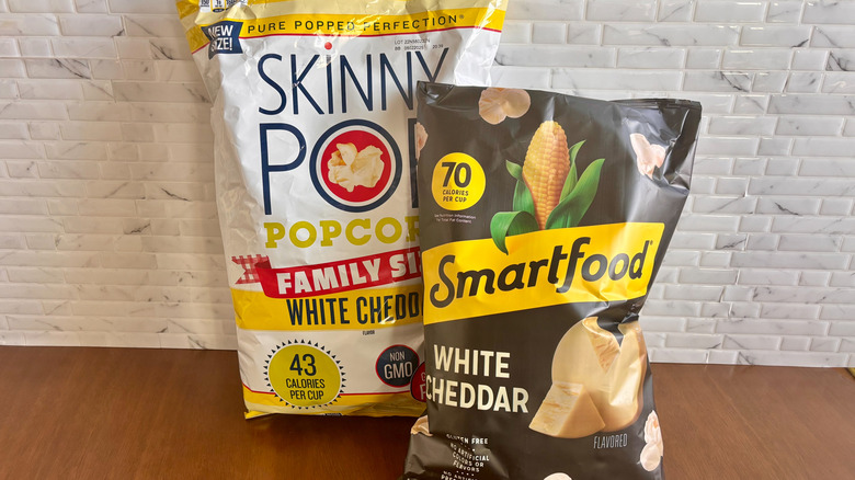 Bags of Skinny Pop and Smartfood popcorn on table