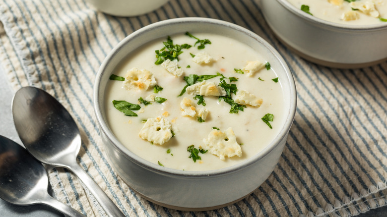 Bowl of creamy soup topped with saltines