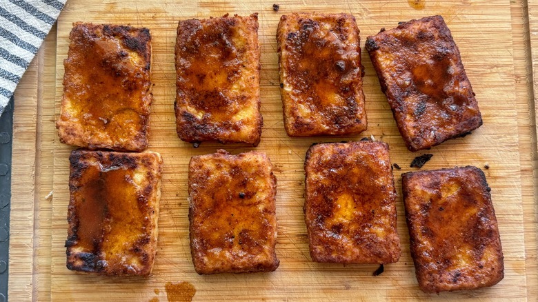 Nashville hot tofu slabs on a wood cutting board