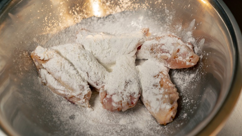 dredging chicken wings in flour