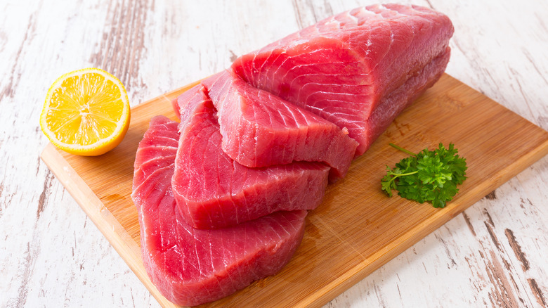 Raw tuna steak on wooden cutting board 