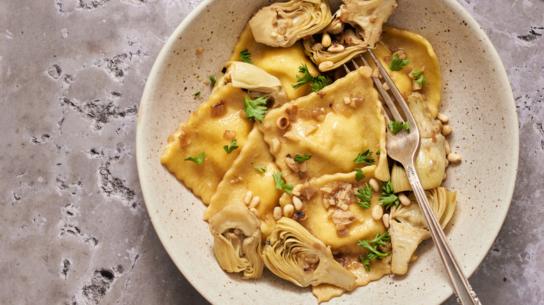 A plate of cheese ravioli and artichokes