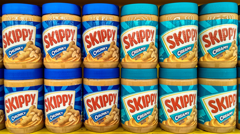 Jars of Skippy peanut butter on a store shelf 