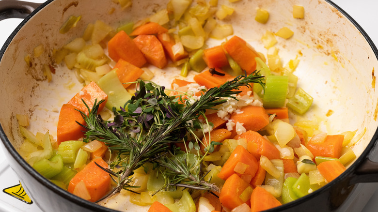 vegetables and herbs cooking in pan