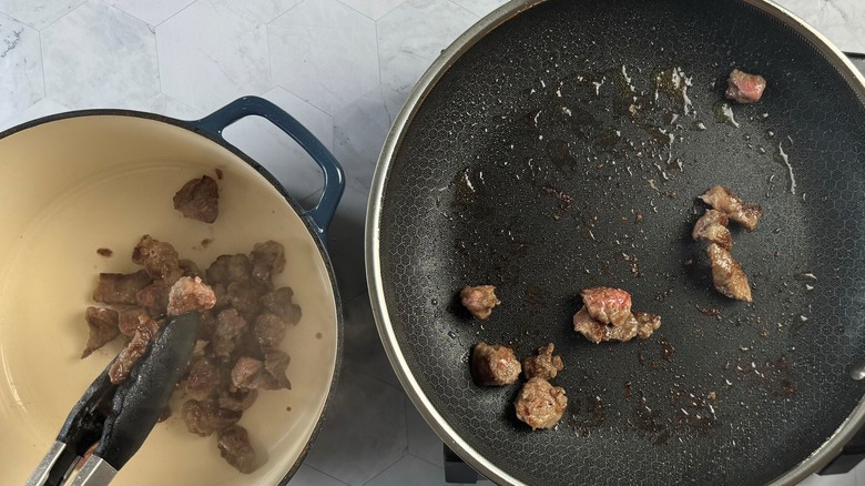 tongs putting meat in pot