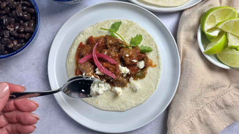 hand putting cheese on tortilla