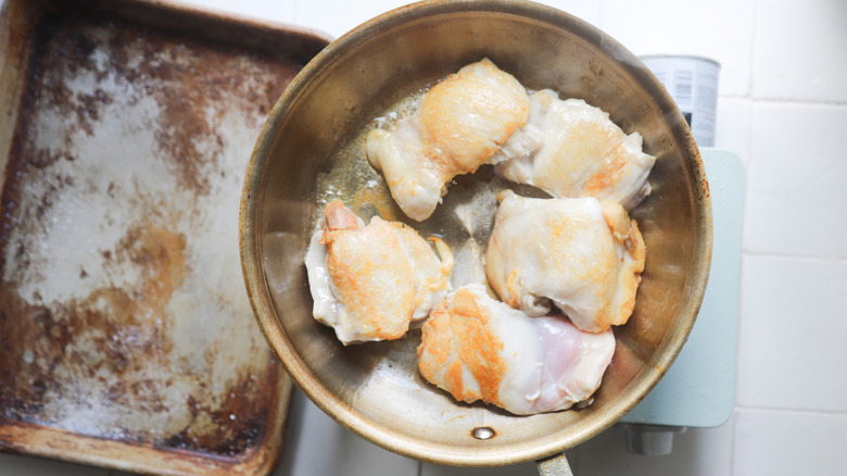 Chicken thighs browning in pan