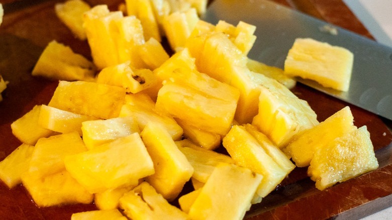 chopped pineapple with knife