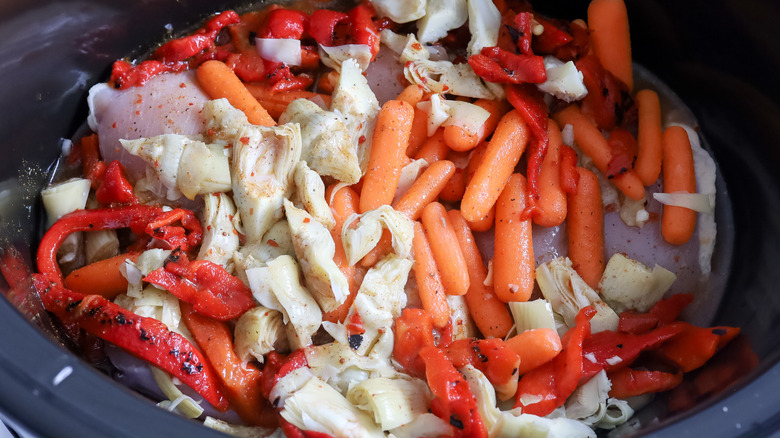 chicken, carrots, artichokes and bell peppers in a slow cooker