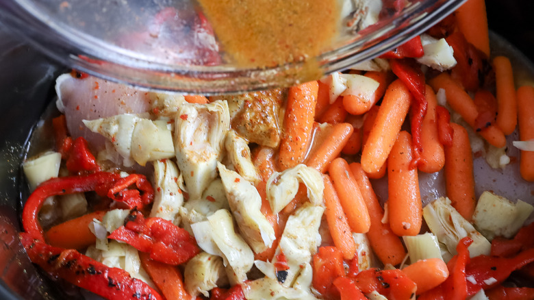 broth being poured over tagine ingredients 