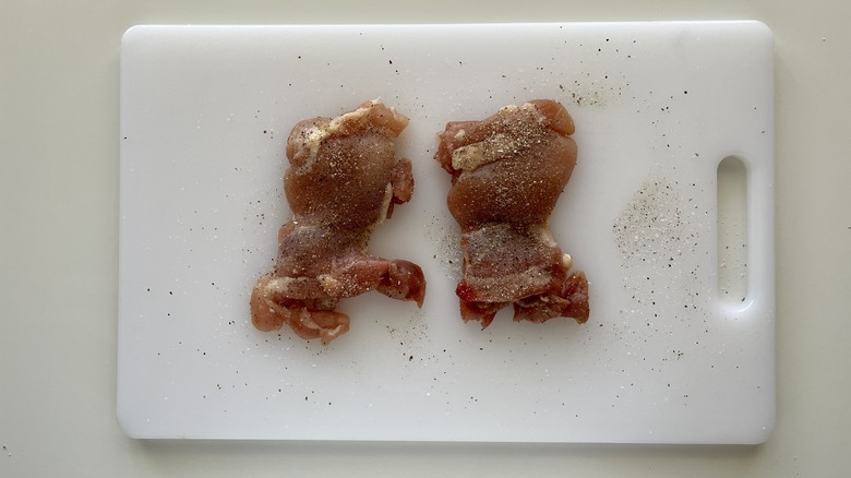 seasoned chicken thighs on cutting board