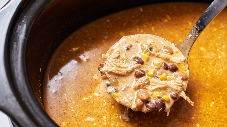 spoonful of soup held over slow cooker