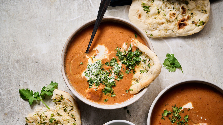 bowls of chicken tikka masala soup with naan