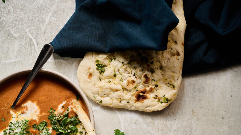 bowl of chicken tikka masala soup with naan