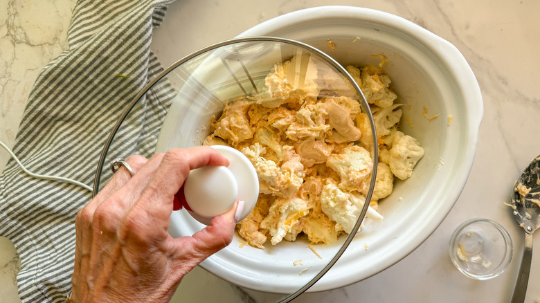 hand covering slow cooker