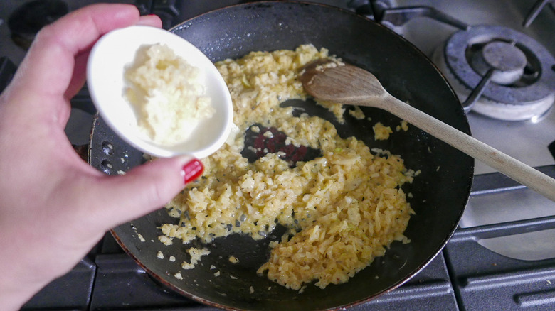 adding garlic to fried onions