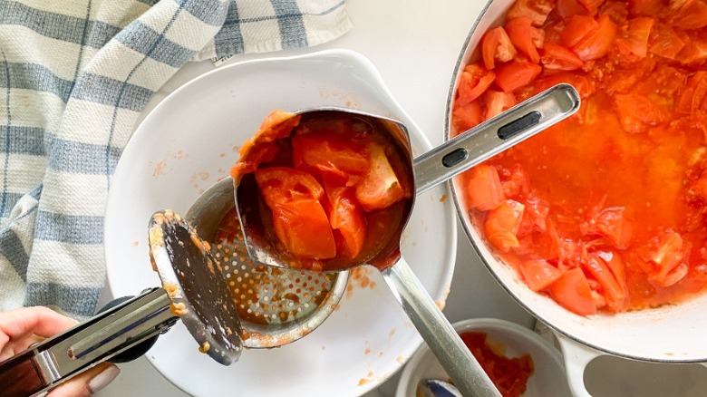 pressing tomatoes in potato ricer