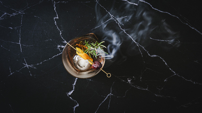 Cocktail with smoking rosemary branch