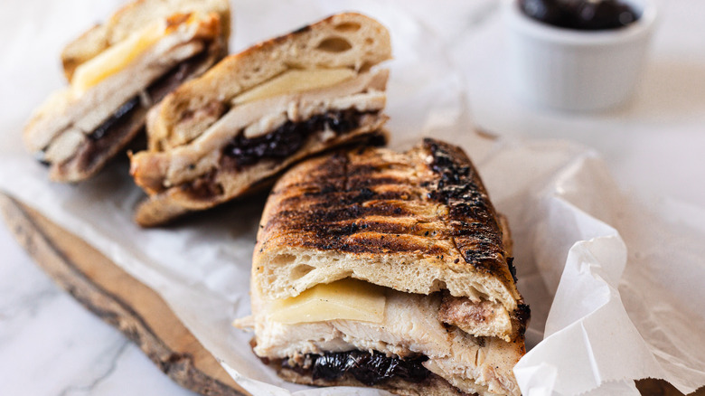 Three slices of panini on parchment paper with cherry chutney