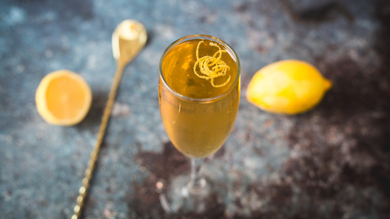 Overhead view of cocktail glass with spoon and lemons