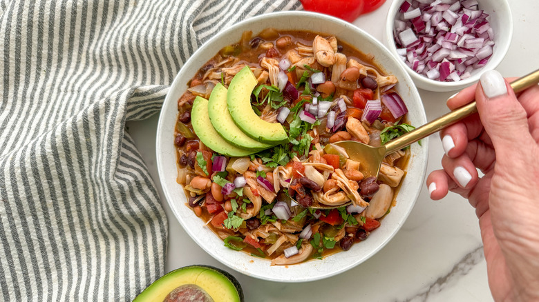 hand spooning out some chili