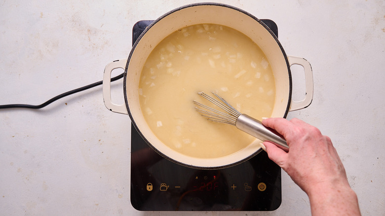 whisking stock into soup