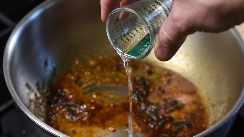 pouring mezcal into pot