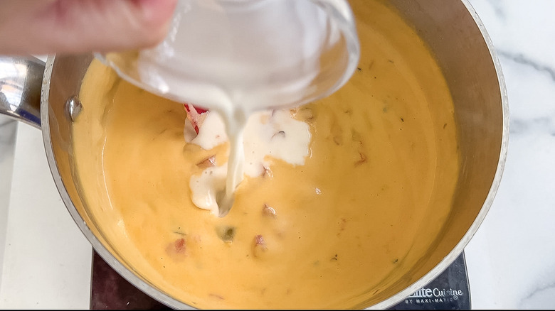 milk being poured into queso